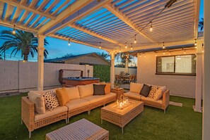 An outdoor patio with a covered seating area, a hot tub, and a fire pit. - Heated Pool|Hot Tub|Ping Pong|Arcade|Pool table (Scottsdale)