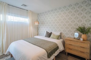 A bedroom with a bed, a bedside table with a mirror, a dresser, and a window with curtains. - Heated Pool|Hot Tub|Ping Pong|Arcade|Pool table (Scottsdale)