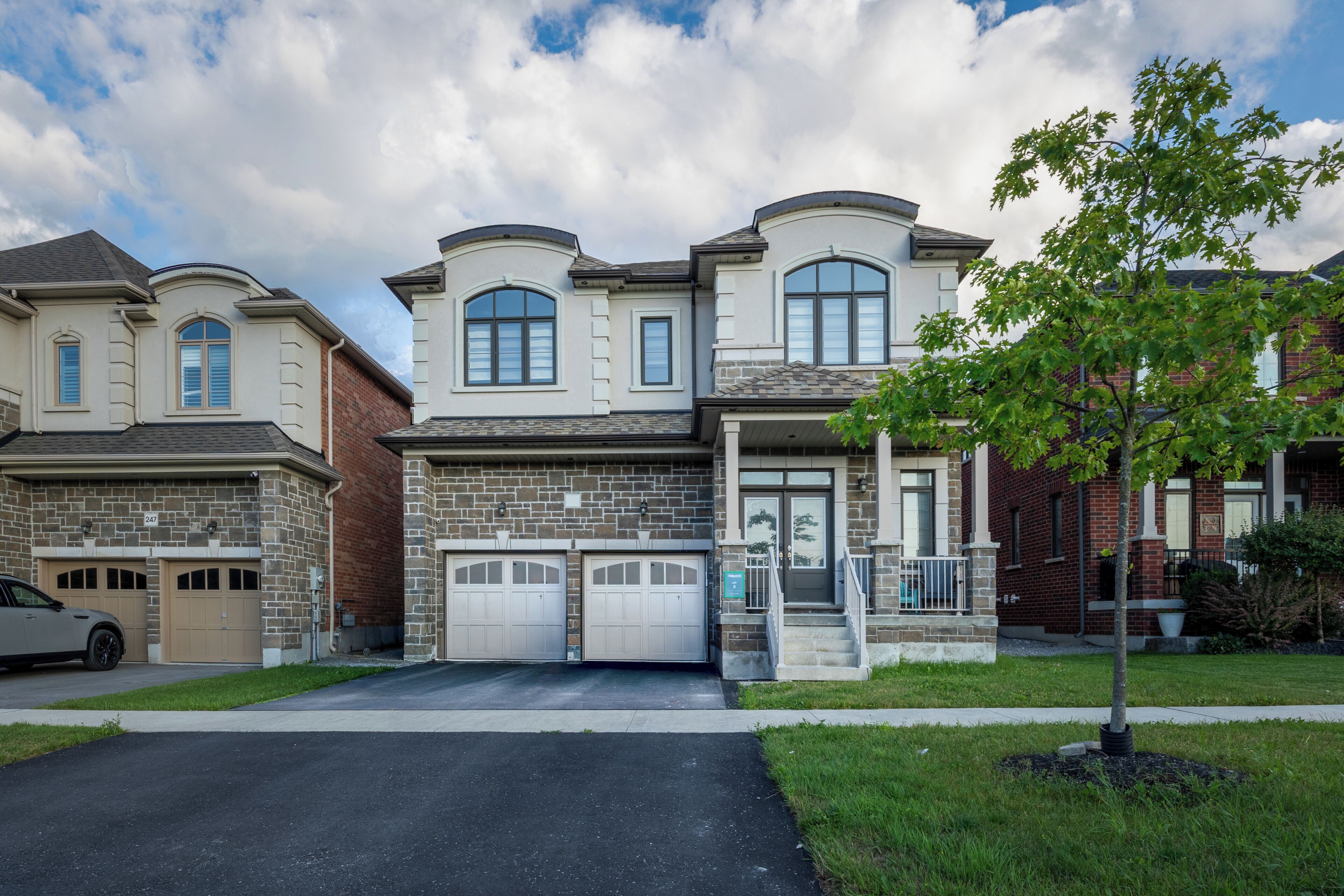 A two-story residential house with a garage, a driveway, and a well-maintained lawn.