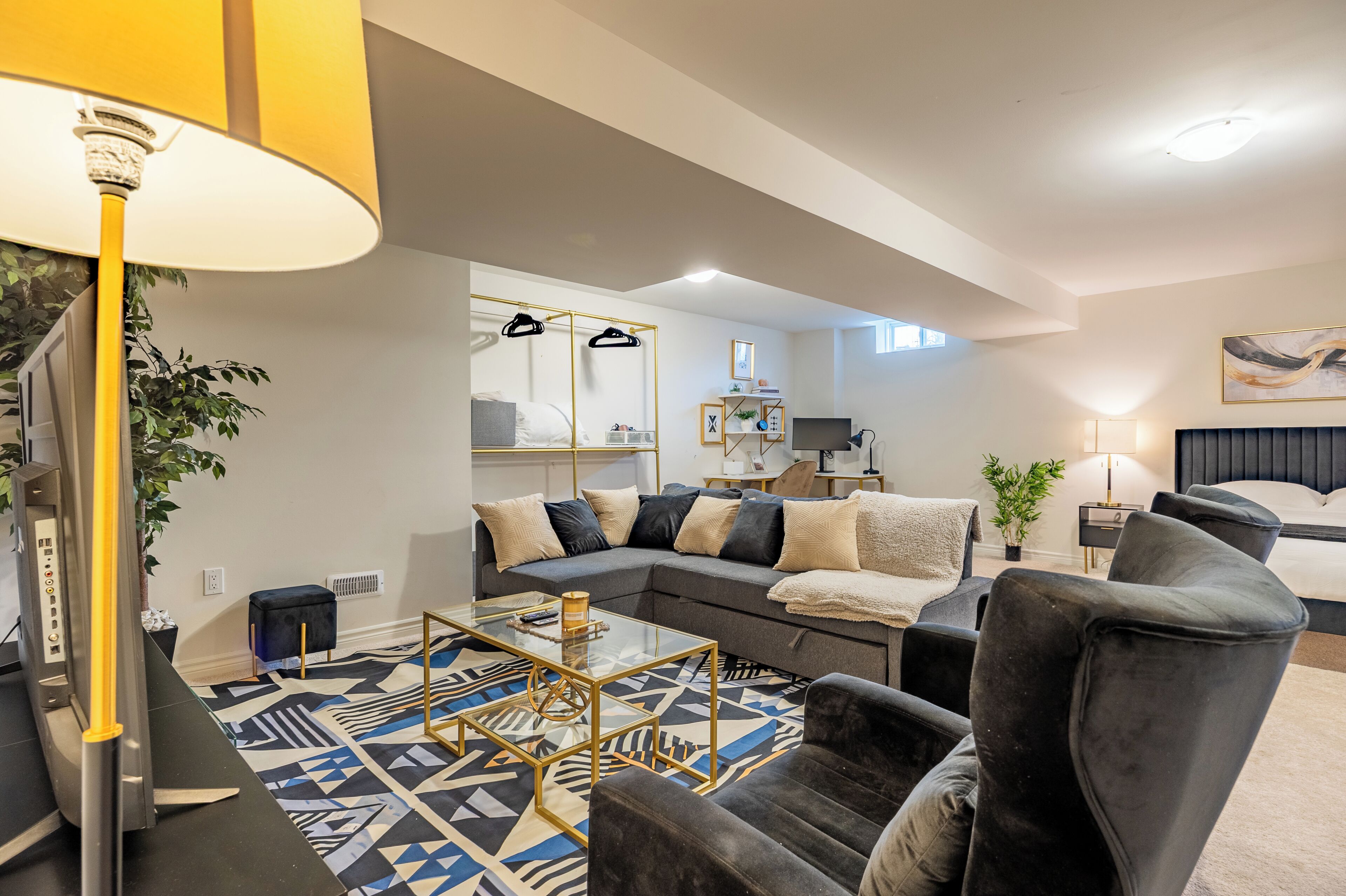 A modern living room with a sectional sofa, a glass coffee table, and a large floor lamp.