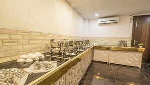 A buffet setup with multiple serving stations, a marble countertop, and a decorative backsplash. - Comfort Home Stay (New Delhi)