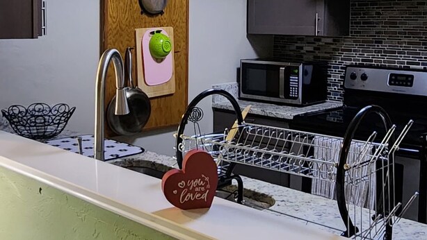 A modern kitchen with a skylight, a wooden backsplash, and a heart-shaped decoration.