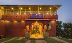 A hotel entrance with a signboard, a covered walkway, and a pathway leading to the entrance. - Eartham Stays Pushkar (Pushkar)