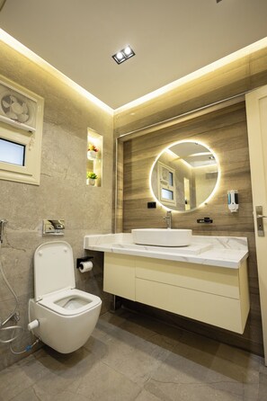 Ein modernes Badezimmer mit Toilette, Waschbecken und Spiegel.