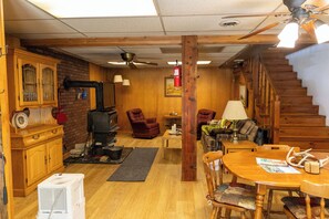 Un interior acogedor con chimenea, muebles de madera, una mesa de comedor y una escalera.