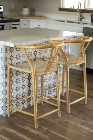 A kitchen with a white countertop, two wooden chairs with woven seats, and a patterned backsplash. - 3-bedroom Desert Escape Near Saguaro Lake & Salt River (Mesa)