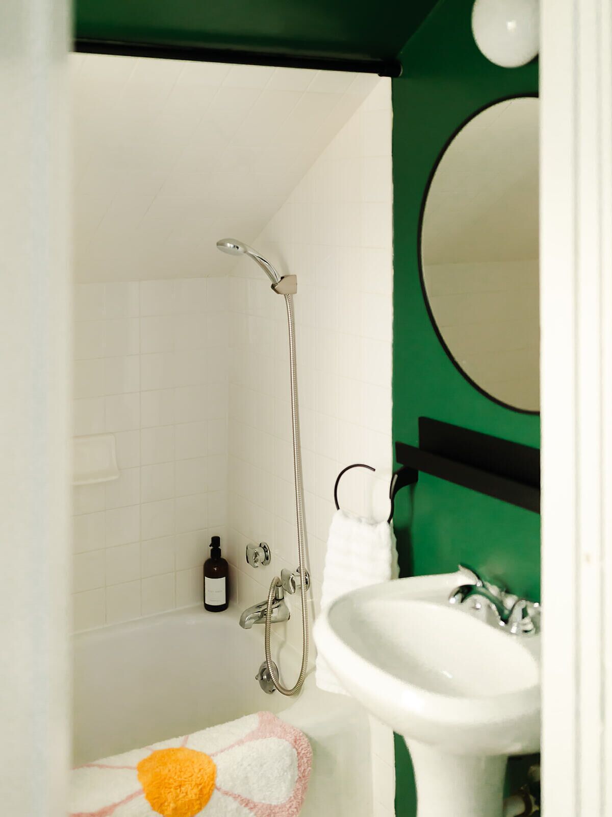 A bathroom with a shower, a sink, and a mirror.
