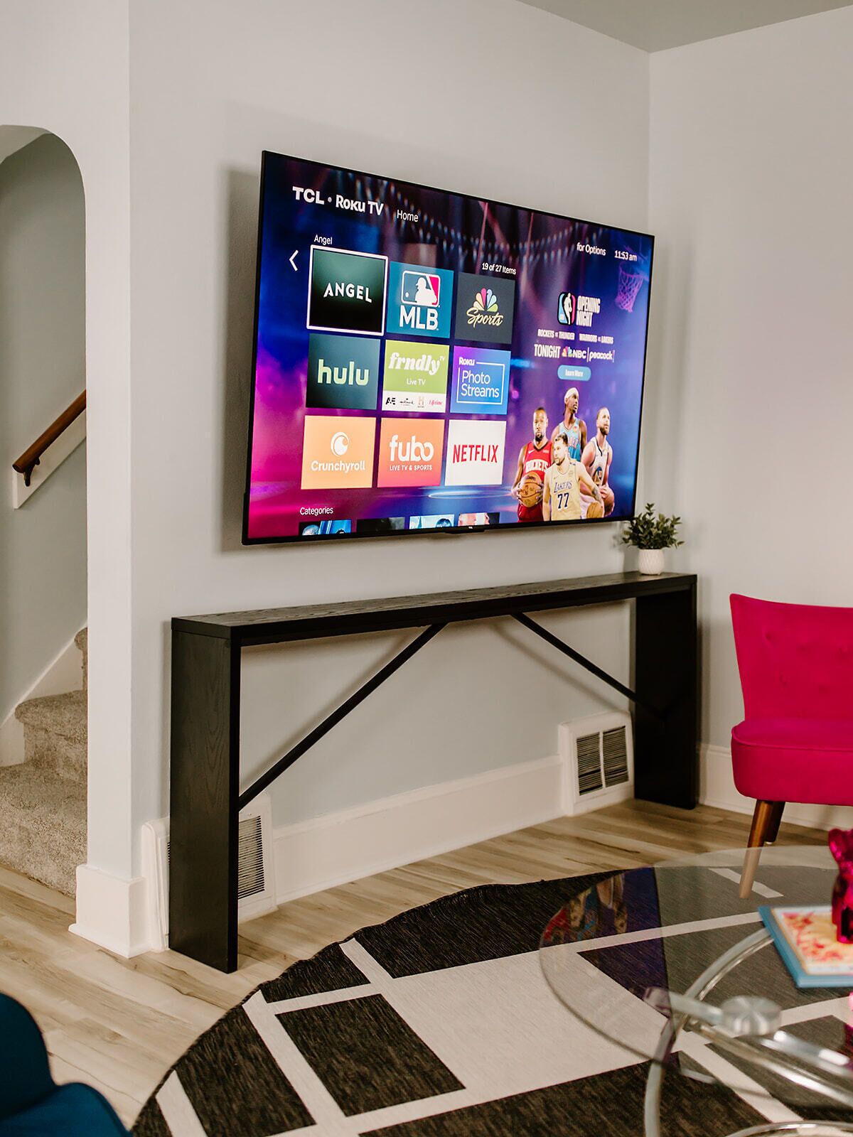 Ein Flachbildfernseher an der Wand montiert, mit TCL-Logo, zeigt verschiedene Streaming-Dienste.