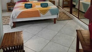 Una camera da letto con un letto, un comodino, una lampada, uno specchio e una ventola a soffitto.