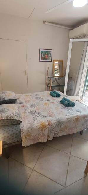 A bedroom with a bed, a mirror, a door, and a window. - 2-bedroom apartment in peaceful Les Trois-Îlets with AC (Les Trois-Îlets)
