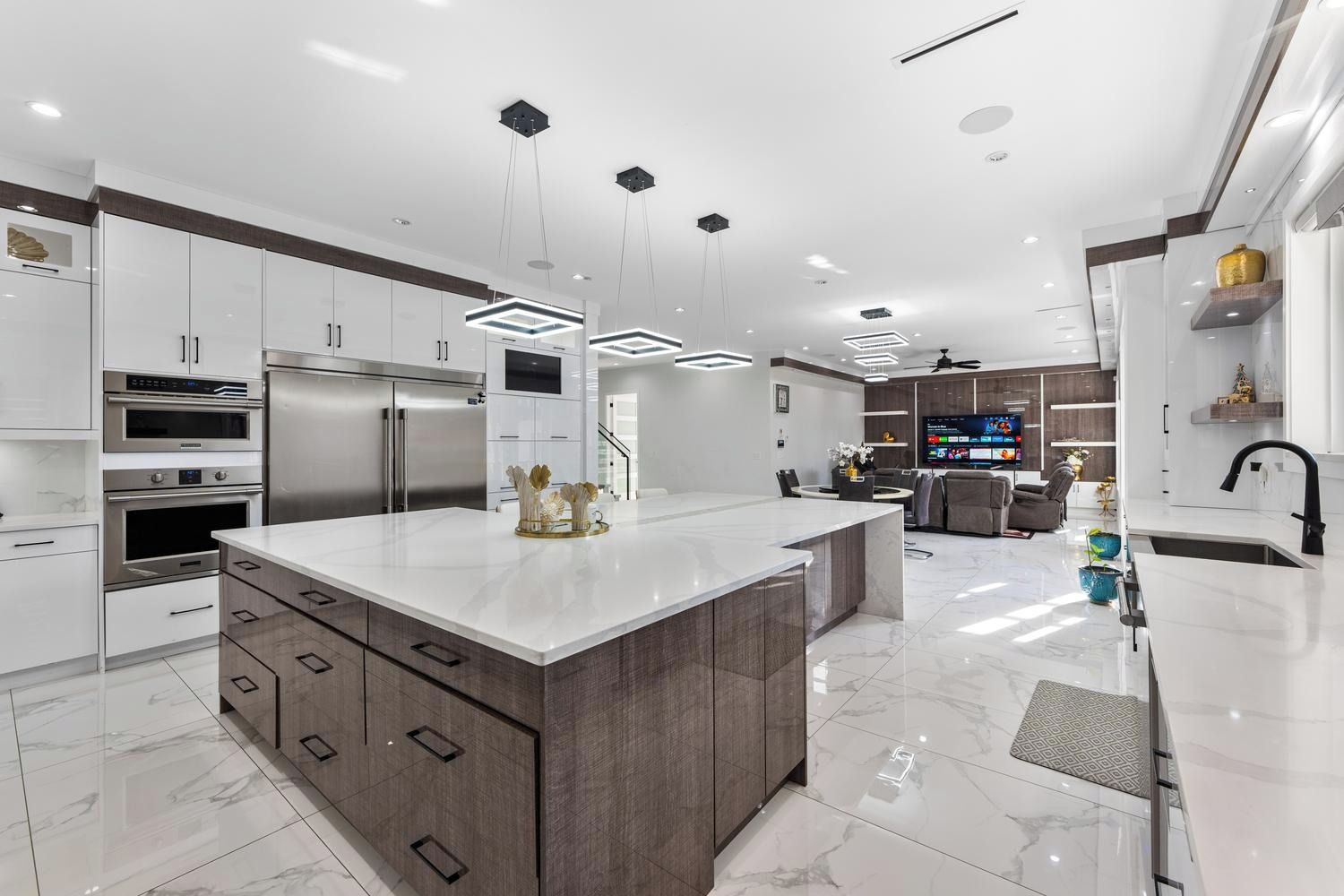 A modern kitchen with a central island, built-in appliances, and a dining area with a TV.
