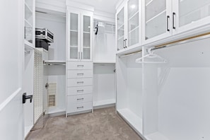 A walk-in closet with white cabinetry, a hanging rod, and a shoe rack. - Grand 5BR Luxury Home ! AC and Home Theater (Surrey)