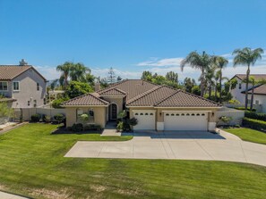 A residential house with a tiled roof, a garage, and a well-maintained lawn. - Welcome to Casa de Las Mariposas! Single Story, 3 Bed, 3 Bath, Fire Pit & Views! (San Marcos)