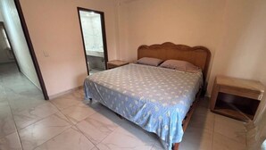 A bedroom with a bed, nightstands, and a wooden headboard. - For rent in one of Manzanillo's most well-equipped and sought-after condominium complexes. (Manzanillo)