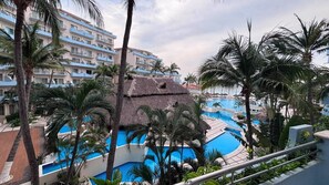 A resort with multiple swimming pools, palm trees, and a building with balconies. - For rent in one of Manzanillo's most well-equipped and sought-after condominium complexes. (Manzanillo)