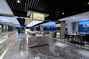 A modern hotel lobby with a marble reception desk, seating area, and large windows offering a city view. - (Shenzhen)