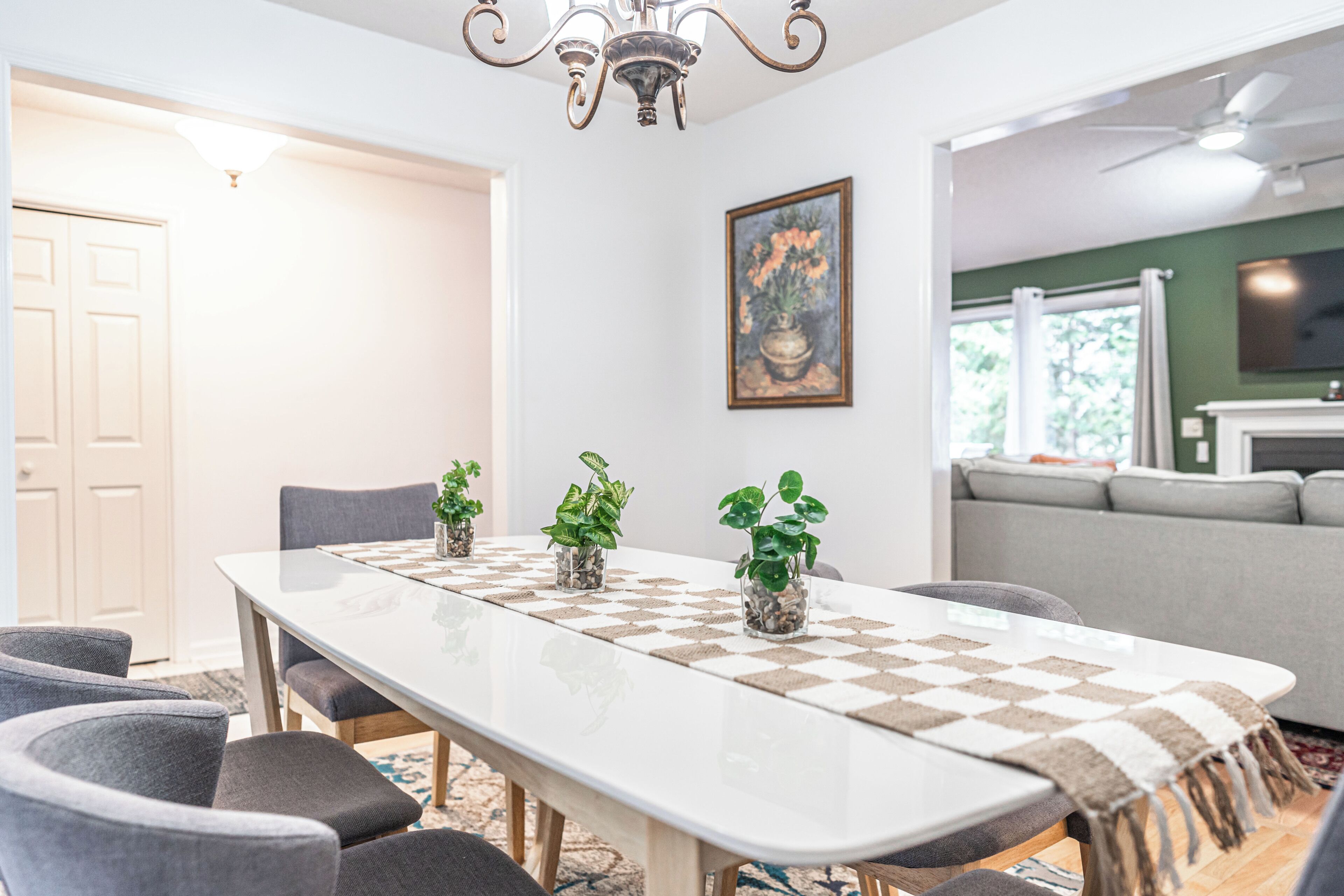 Un espace repas avec une longue table, des chaises et des plantes en pot.