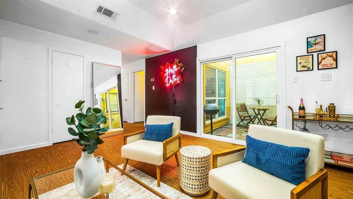 A modern living room with a sofa, armchairs, a coffee table, and a decorative wall.