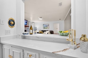 A modern kitchen with white cabinetry, a marble countertop, and gold fixtures. - Sunshine Shores-Waterfront Lake Granbury Getaway • Sleeps 10 (Granbury)