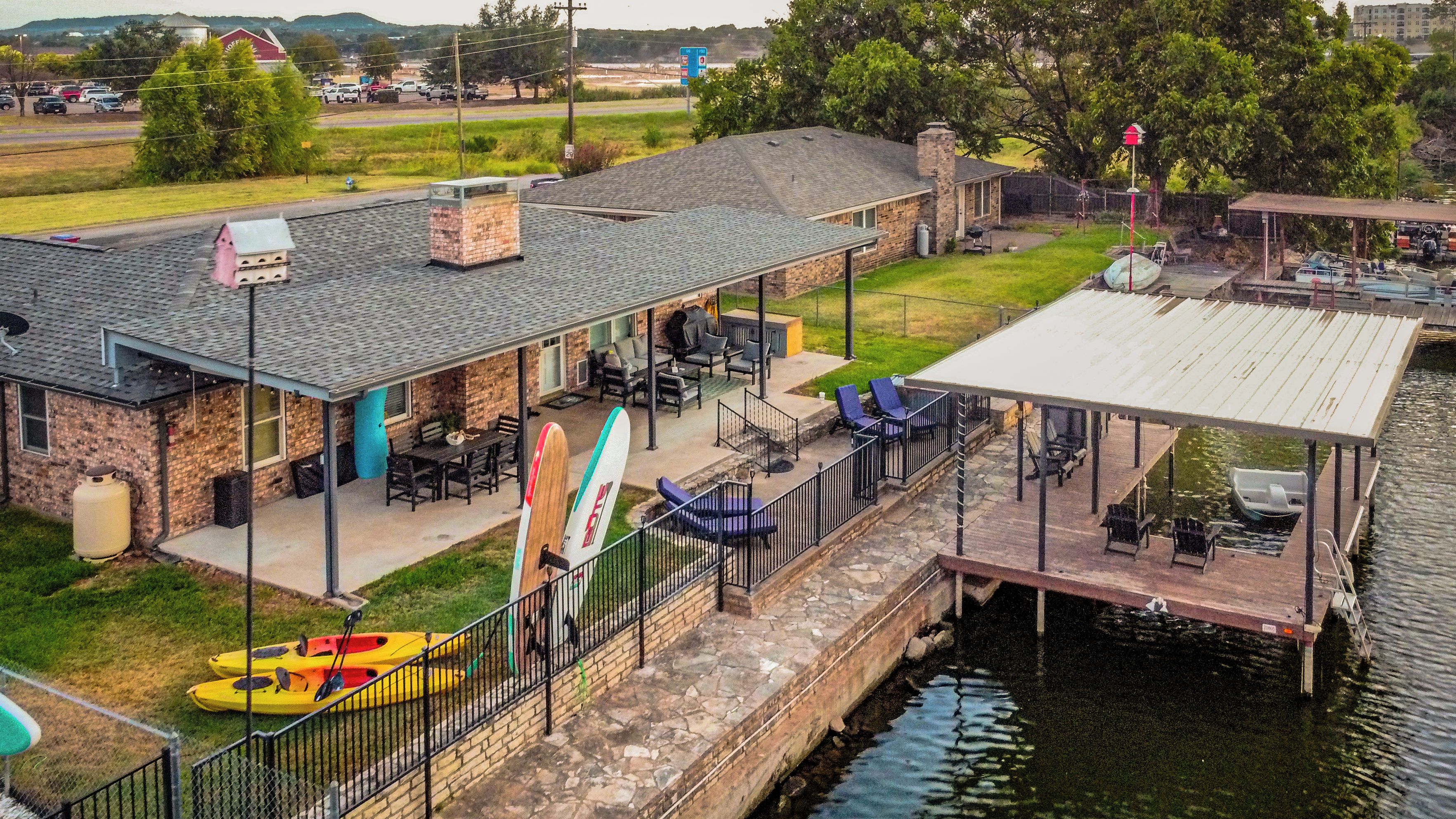 A waterfront property with a covered patio, outdoor seating, and a dock.