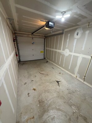 A garage with a closed garage door, concrete floor, and visible plumbing. - 2 Bed 2.5 Bath Townhome with En-Suite bathrooms (Oregon City)