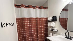 Een badkamer met toilet, wastafel en douchegordijn.