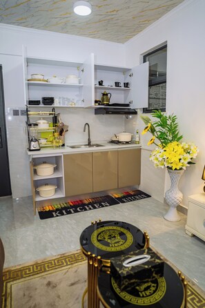 A modern kitchen with white cabinetry, a built-in oven, and a variety of kitchenware. - Modern 1BR at Golden Mango Heights  Gym, Sauna, Washer & Dryer (Nairobi)