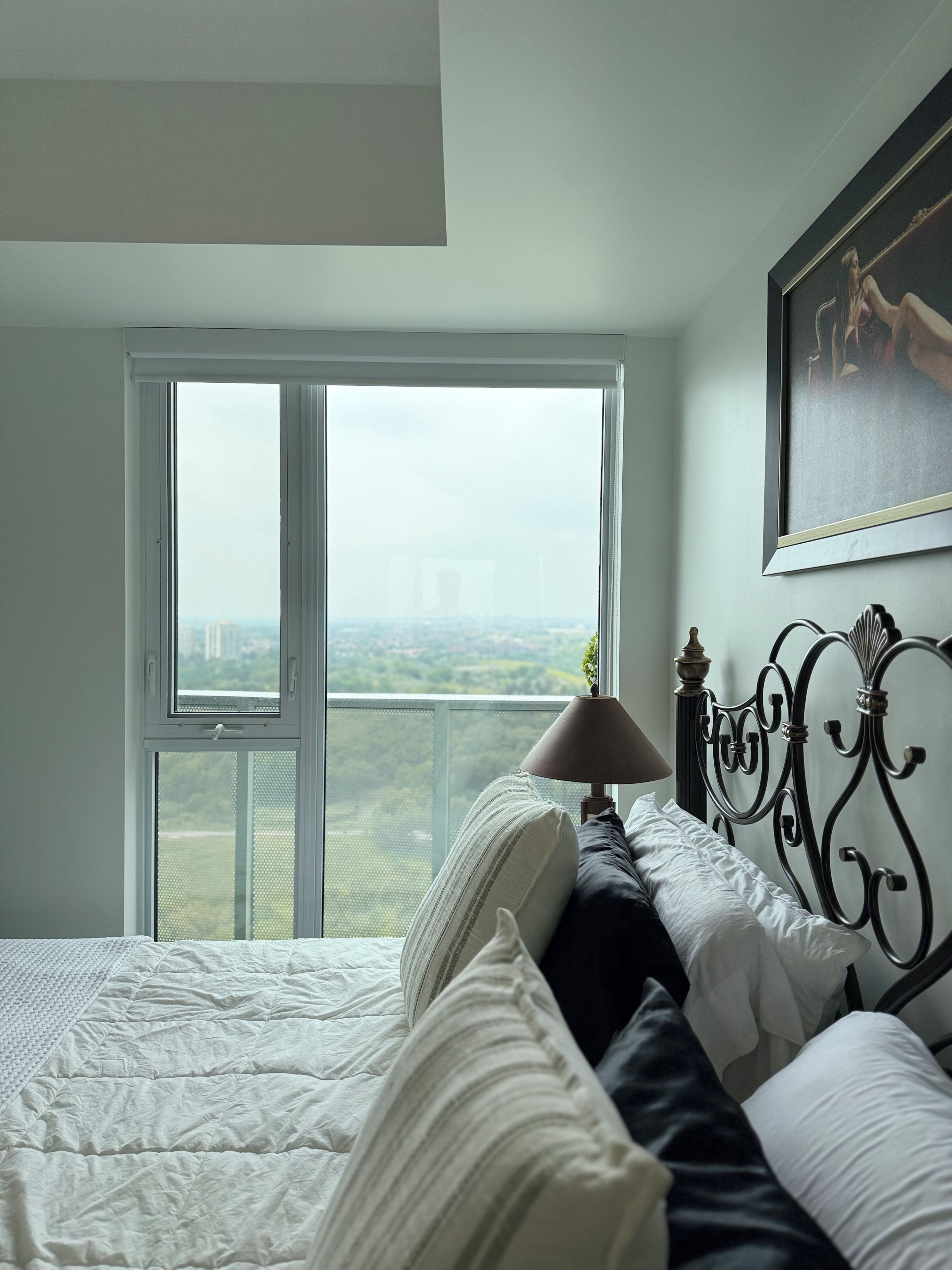 Un dormitorio con una cama, una ventana y una lámpara.