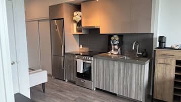 Une cuisine moderne dotée d’un réfrigérateur en acier inoxydable, d’un four double et d’un plan de travail en bois.