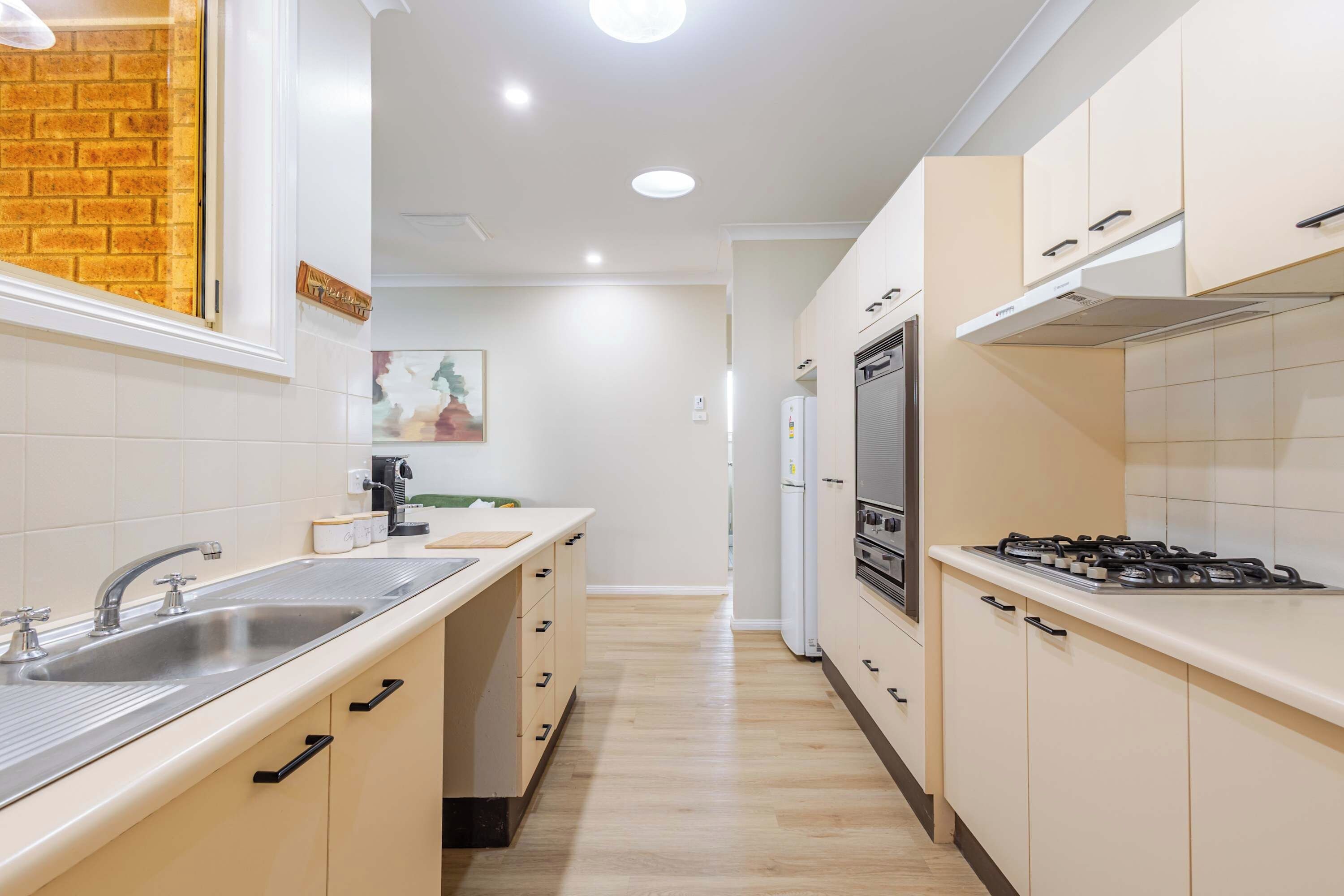 A modern kitchen with a central island, stainless steel appliances, and a view into the dining area.