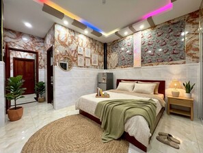 Una camera da letto moderna con un letto grande, comodini, uno specchio e una parete con motivi decorativi.