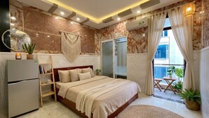 Quarto com cama, guarda-roupa, mesa de cabeceira, espelho, prateleira pequena e planta em vaso.