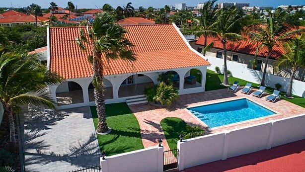 A residential property with a swimming pool, a covered patio, and a view of a cityscape. - Renovated 3BR Home Private PoolClose 2 BeachBBQ (Noord)