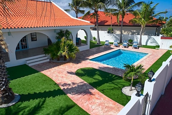 An inviting poolside oasis surrounded by natural greenery—the perfect spot to unwind, take a dip, and soak up the peaceful atmosphere.