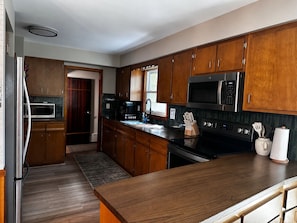A modern kitchen with wooden cabinets, stainless steel appliances, and a large island.