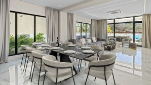 Un comedor amplio con techo alto, ventanas grandes y vistas al exterior.