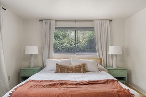 A bedroom with a bed, two nightstands, a window with blinds, and curtains. - Entire Home-Charming Historic Adobe Prime Location (Santa Fe)