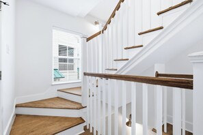 A staircase with wooden steps and white railings. - Sunnyside - 30a Blue Mountain Beach -Golf Cart or Walk to Beach With Ease (Santa Rosa Beach)
