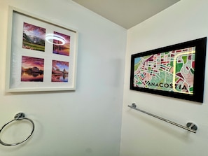Eine Wand mit einem gerahmten Foto des Weißen Hauses und einer Karte von Anacostia.