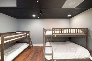 A room with two bunk beds, wooden flooring, and a ceiling with recessed lighting. - Lake Norman Private Getaway with Pool, Hot Tub & Game Room (Denver)