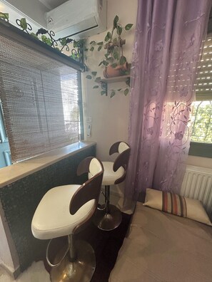A small kitchenette with a window, two bar stools, a radiator, and a curtain. - THE MEDINA Rooftop
it’s a spacious villa in the peaceful heights of Montfleury (Tunis)