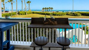 Ein Balkon mit Meerblick, ein Pool und Palmen.