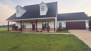 A two-story house with a covered porch and a garage.