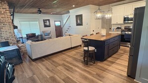 A spacious kitchen with a wooden ceiling, a large island, and modern appliances.