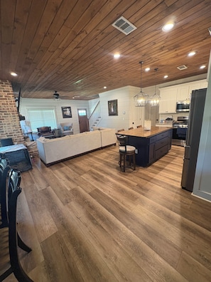 Una cocina amplia con techo de madera, una isla grande y electrodomésticos modernos.