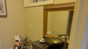 A bathroom with a large mirror, a vanity with a bowl sink, and a toilet. - Home in Richmond Hill. Cozy, clean and friendly (Richmond Hill)