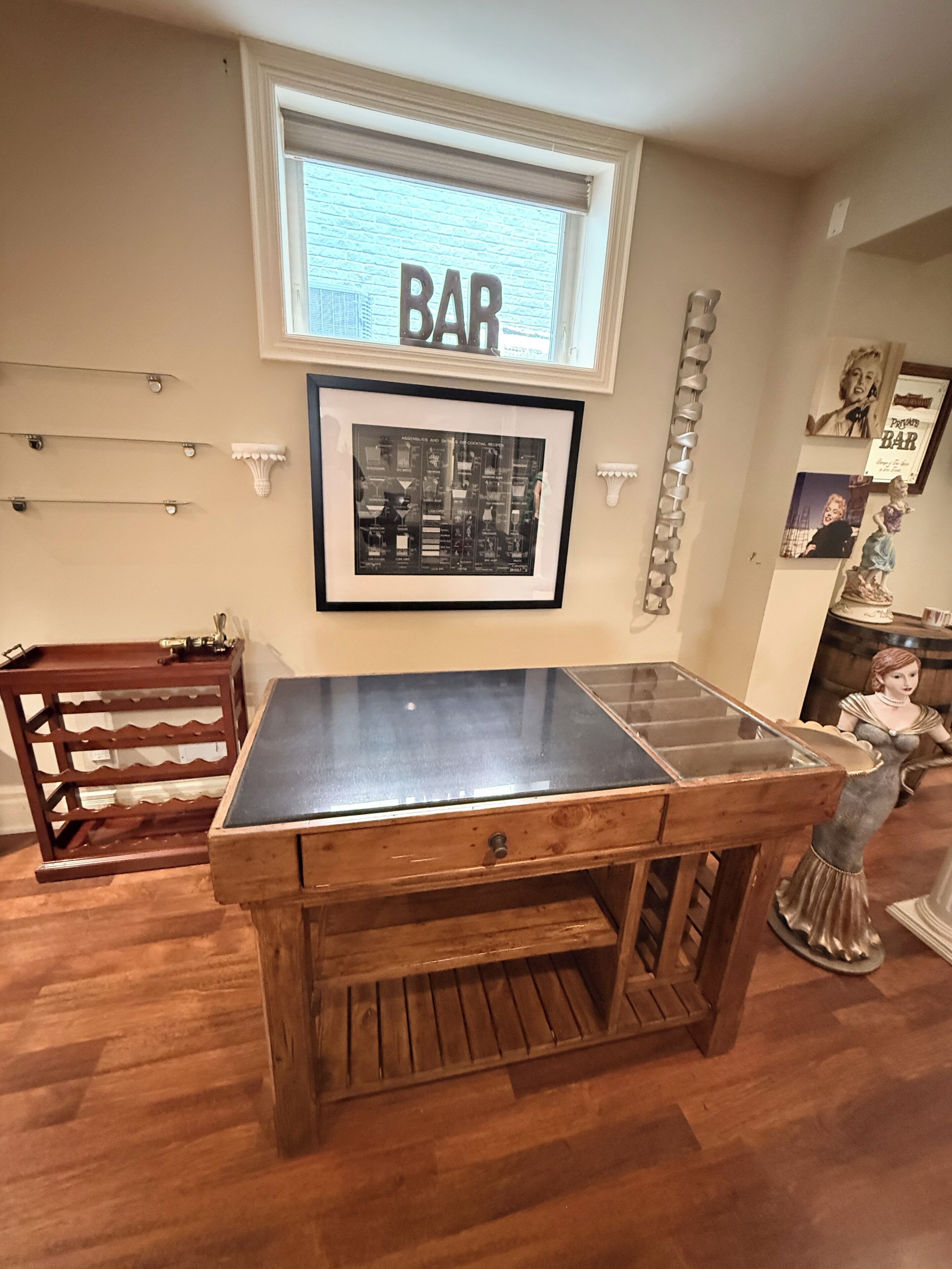 Un espace bar agrémenté d’un menu encadré, d’un comptoir en bois et d’une statue décorative.