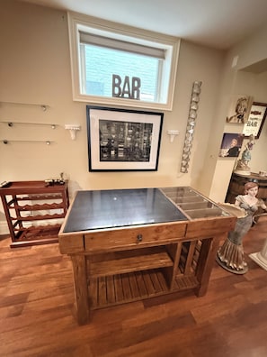 A bar area with a framed menu, a wooden bar counter, and a decorative statue. - Home in Richmond Hill. Cozy, clean and friendly (Richmond Hill)
