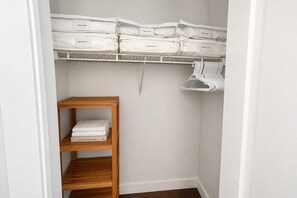 A closet with storage bins labeled 'DUVET COVER' and 'KING SHEET SET'. - 3 bedroom downtown condo - sleeps 6 (Kelowna)