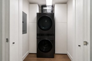 A laundry room with two stacked washing machines and a dryer. - 3 bedroom downtown condo - sleeps 6 (Kelowna)
